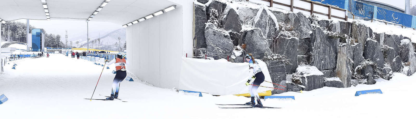 Eine sehbehinderten Ski-Langläuferin läuft mit ihrem Guide auf der Zielgeraden